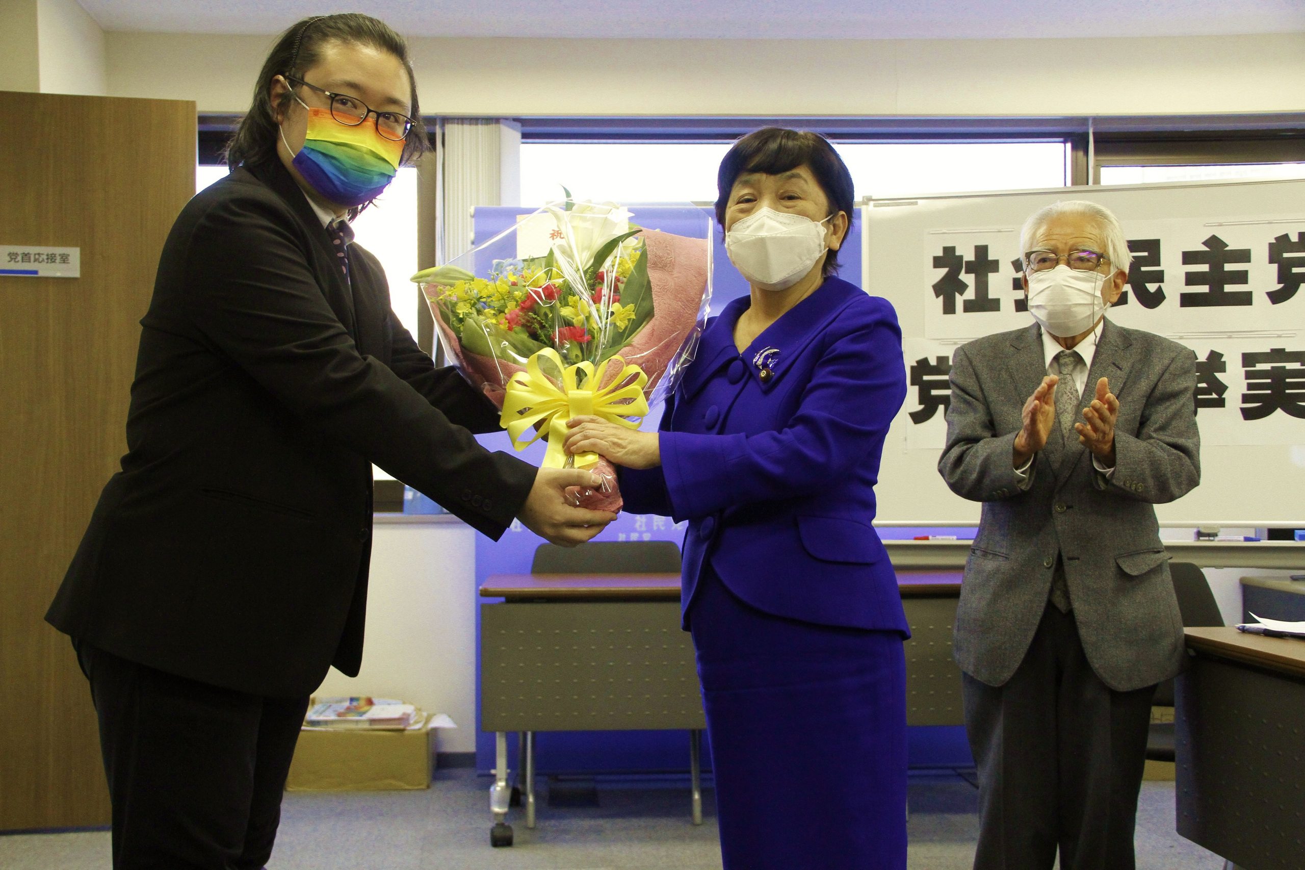 事務局員から「当選祝い」の花束を受け取る福島党首
