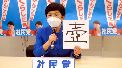 「壺」と書かれた紙を持ち会見する福島党首（１２月１４日）。